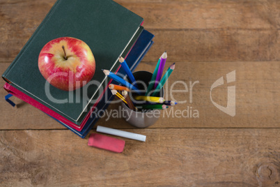 School supplies and books stack with apple on top