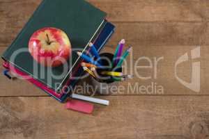 School supplies and books stack with apple on top