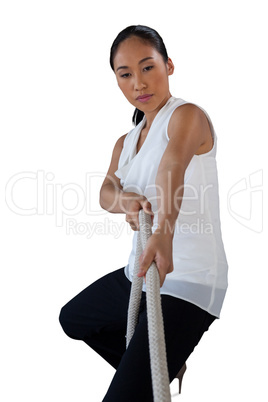 Woman looking away while pulling rope
