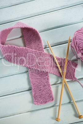 Close-up of pink woolen Breast Cancer Awareness ribbon with crochet needles