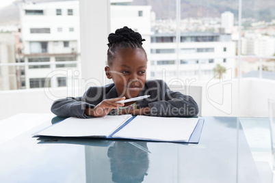 Thoughtful businesswoman with document looking away at table