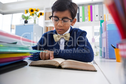 Businessman reading book while sitting at desk