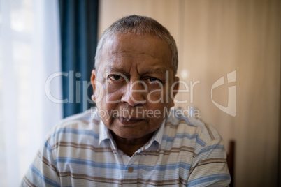 Portrait of senior man sitting by window