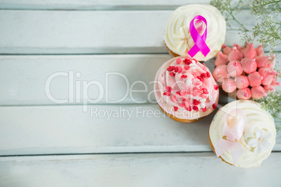 Overhead view of Breast Cancer Awareness pink ribbons on cupcakes