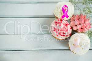 Overhead view of Breast Cancer Awareness pink ribbons on cupcakes
