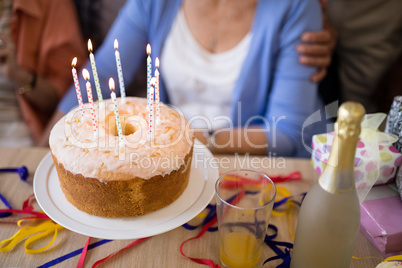 Close-up of candles on birthday cake by senior people