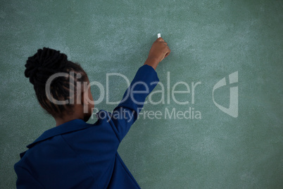 Rear view of businesswoman writing on chalkboard