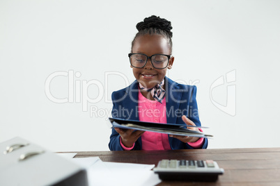 Smiling businesswoman wearing eyeglasses holding file