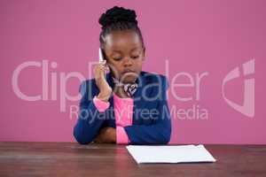 Concentrated businesswoman using mobile phone at desk