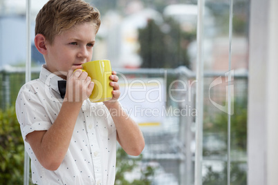 Thoughtful businessman looking away while holding yellow coffee mug