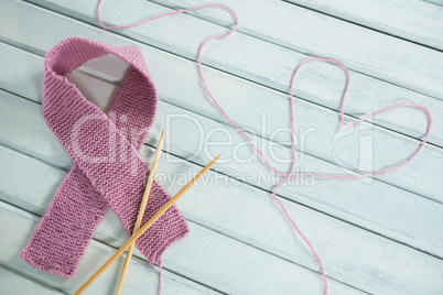 Close-up of pink Breast Cancer Awareness ribbon by crochet needles with heart shape