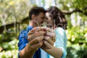 Couple holding engagement ring
