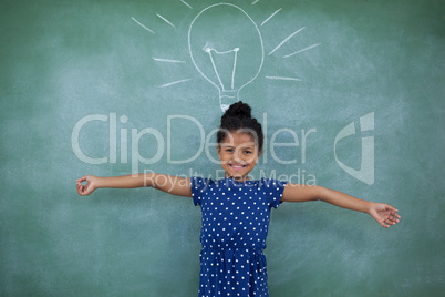 Portrait of girl with arms outstretched by bulb drawing on wall