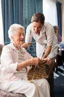 Senior woman showing knitting to female doctor