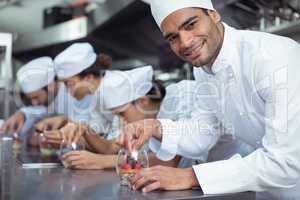 Chefs finishing dessert in glass at restaurant