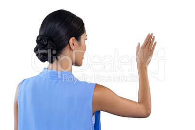 Rear view of businesswoman touching interface