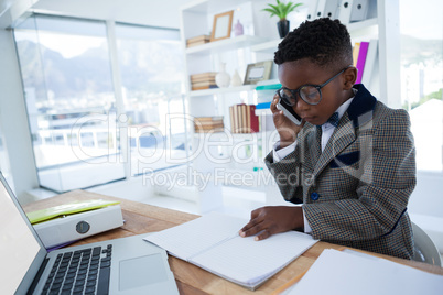 Businessman reading report while talking on phone