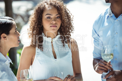 Friends interacting while having glass of wine