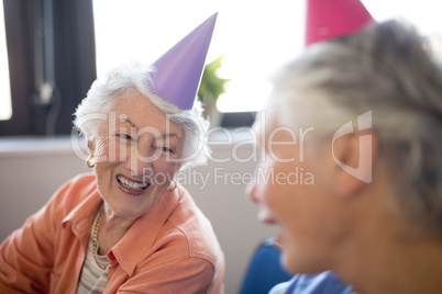 Smiling senior women wearing party hats