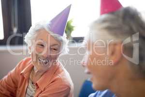 Smiling senior women wearing party hats
