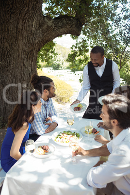 Waiter serving food to customers