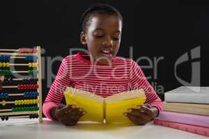 Schoolgirl reading a book against black background