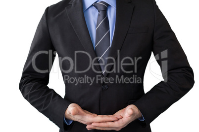 Mid section of businessman in suit while standing with hands cupped