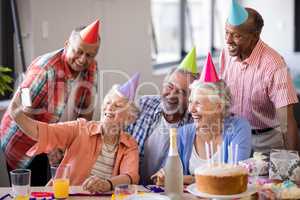 Smiling senior people taking selfie at party