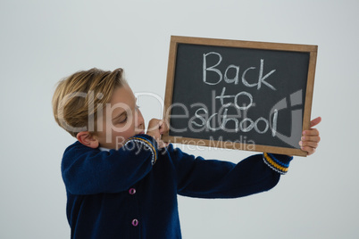 Schoolboy holding slate with text against white background Schoolboy holding slate with text against white background