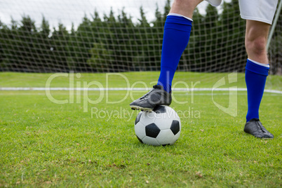 Low section of soccer player with ball on field