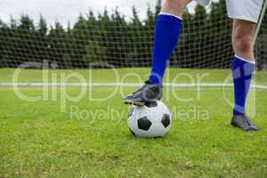 Low section of soccer player with ball on field