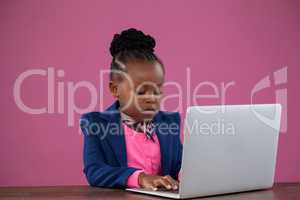 Serious businesswoman using laptop at desk