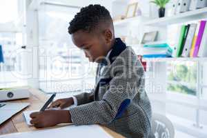 Serious businessman writing report at desk