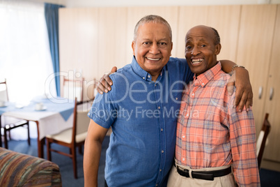 Portrait of smiling senior friends standing with arms around