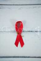 Overhead view of red AIDS awareness ribbon on table