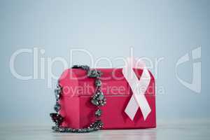 Close-up of jewelry with red box and pink Breast Cancer Awareness ribbon