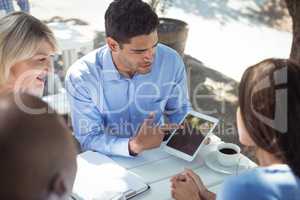 Friends discussing over digital tablet