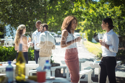 Friends interacting while having glass of wine in restaurant