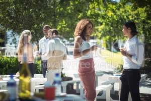 Friends interacting while having glass of wine in restaurant