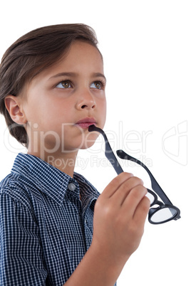 Thoughtful boy holding spectacles