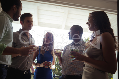 Group of friends interacting with each other while having cocktail drink