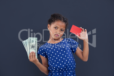 Portrait of girl showing currency and credit card
