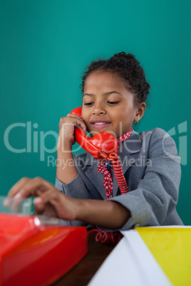 Close up of smiling businesswoman dialing numbers on land line phone