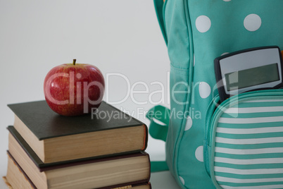 Apple, books, calculator and schoolbag on white background