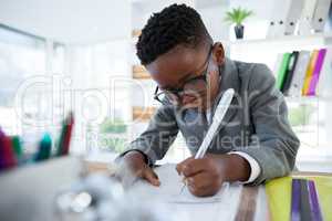 Businessman writing on paper at desk