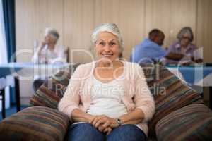Portrait of happy senior woman sitting on couch
