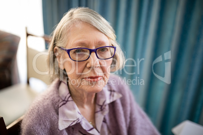 Portrait of senior woman sitting on chair at nursing home