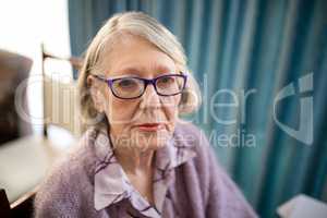 Portrait of senior woman sitting on chair at nursing home