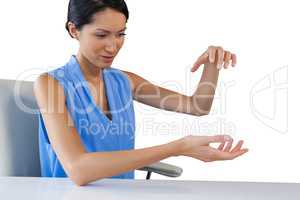 Businesswoman holding something while sitting at table