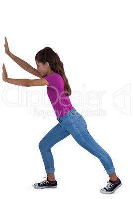 Girl pushing against white background